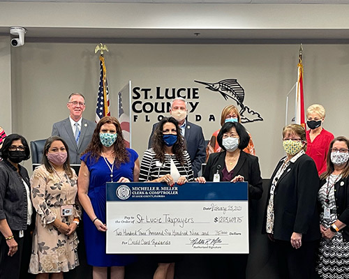 Clerk Michelle  Miller presents a check to the St. Lucie County Board of County Commissioners with the Accounts Payable Department