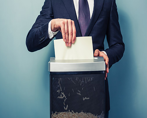 Man putting paper in a shredder